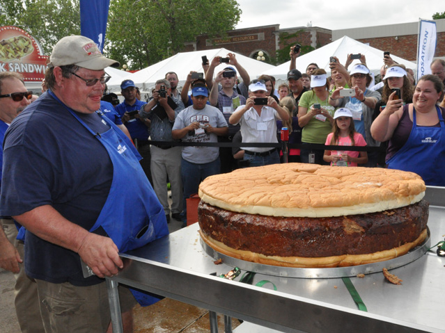 Gary Vinsand of Vinny&#039;s BBQ in Dakota City, Iowa, stands next to the world&#039;s largest pork burger, which, before cooking, weighed 345 pounds. The burger took about eight hours to cook at the World Pork Expo in Des Moines Thursday. (DTN photo by Chris Clayton)